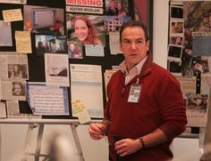 a man standing in front of a bulletin board