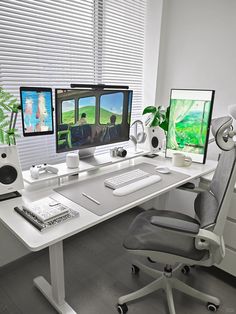 a computer desk with two monitors and a keyboard on it in front of a window