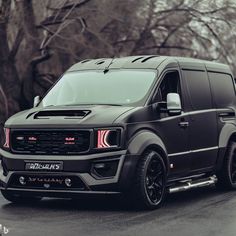 a black van is parked in front of some trees