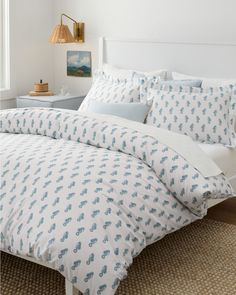 a bed with blue and white comforters in a bedroom