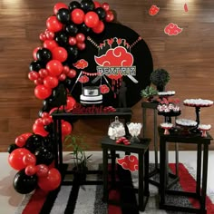 a black and red balloon arch with chinese writing on it, along with other decorations