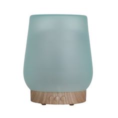 a blue glass lamp sitting on top of a wooden base