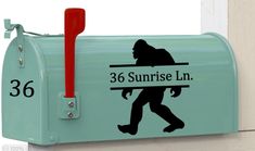 a blue mailbox with a bigfoot on it's side and the words, 36 sunrise ln