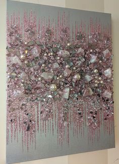 an abstract painting with pink and silver colors on a gray background is featured in this image