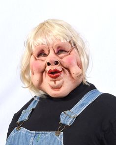 a woman with blonde hair wearing overalls and a creepy face