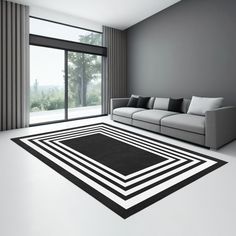 a modern living room with black and white rugs on the floor next to a couch