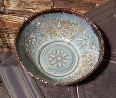 a blue bowl sitting on top of a tile floor