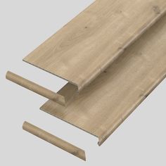 two pieces of wood are laying next to each other on a gray background, with one piece missing from the floor