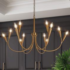 a gold chandelier with lights hanging from it's sides in a kitchen