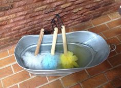 two buckets filled with cleaning supplies on top of a brick floor