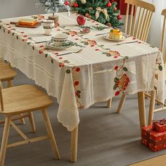 a dining table with two chairs and a christmas tree in the background