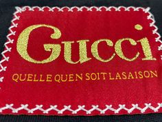 a gucci label on a black jacket with red and gold trimming around it