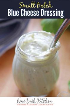 a jar filled with cream sitting on top of a wooden table next to a spoon