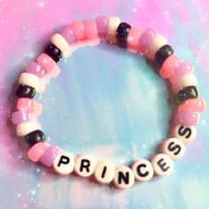 a pink and black beaded bracelet with the word princess spelled in small letters on it