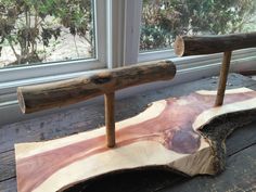 two pieces of wood sitting on top of a wooden table next to a windowsill