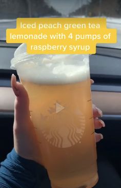 a person holding up a cup with liquid in it