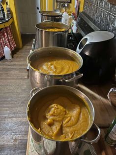 three pots filled with food sitting on top of a counter