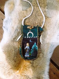 a small purse with an image of a woman on it hanging from a fur rug