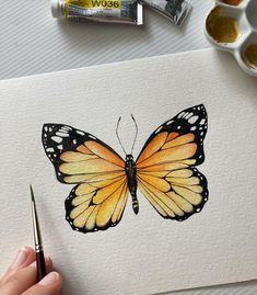 someone is painting a butterfly with watercolors