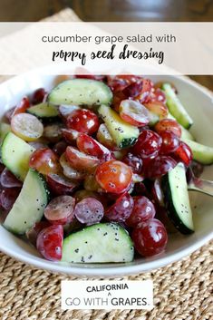 cucumber grape salad with poppy seed dressing in a white bowl on a woven placemat