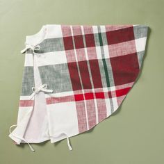 a red and white checkered blanket on top of a green wall with two ties tied to it