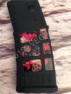 the case is made out of black material with skulls and flowers on it, as well as red roses