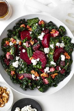 a white bowl filled with beets, feta cheese and walnuts on top of a table