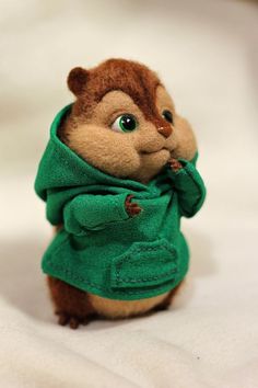 a stuffed animal with a green jacket on