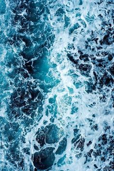 an aerial view of the ocean waves and rocks