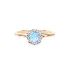 a gold ring with an oval opal and diamond halo around the band, on a white background