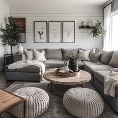 a living room filled with lots of furniture next to a window and potted plants