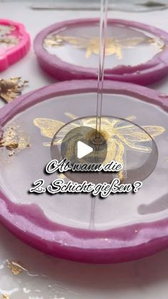 some pink and purple plates with gold designs on them, sitting on a white table