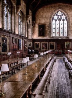 the long tables are lined up in the large room with stained glass windows and wooden flooring