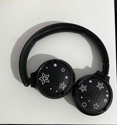 black headphones with stars on them sitting on top of a white table next to each other