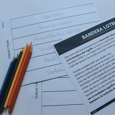 several different colored pencils sitting next to each other on top of some sheets of paper