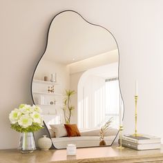 a mirror sitting on top of a dresser next to a white couch