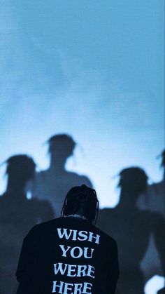 a person standing in front of a group of people with their shadows on the wall