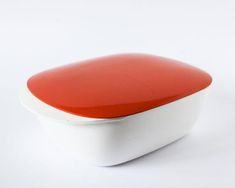 a red and white container with lid on a white surface