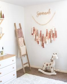 a child's room with a rocking horse and wall hangings on the wall