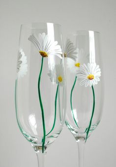 three wine glasses with daisies painted on them