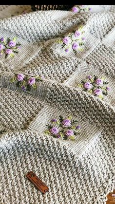 a crocheted blanket with purple flowers on it