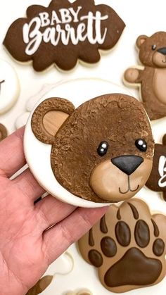 a hand holding a cookie decorated like a bear