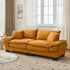 a living room scene with focus on the couch and rugs in front of the window