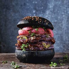 a very large hamburger sitting on top of a wooden table