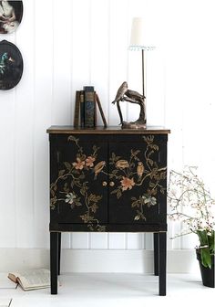 a black cabinet with flowers painted on it