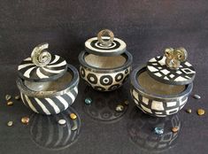 three black and white containers sitting on top of a table