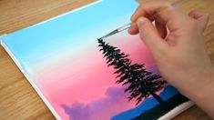 someone is painting a tree on a piece of paper