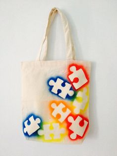 a tote bag with puzzle pieces painted on it