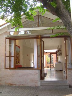 the inside of a house with an open door and windows on each side of it