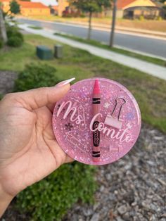 a person holding up a pink sticker with the word miss dynamite written on it